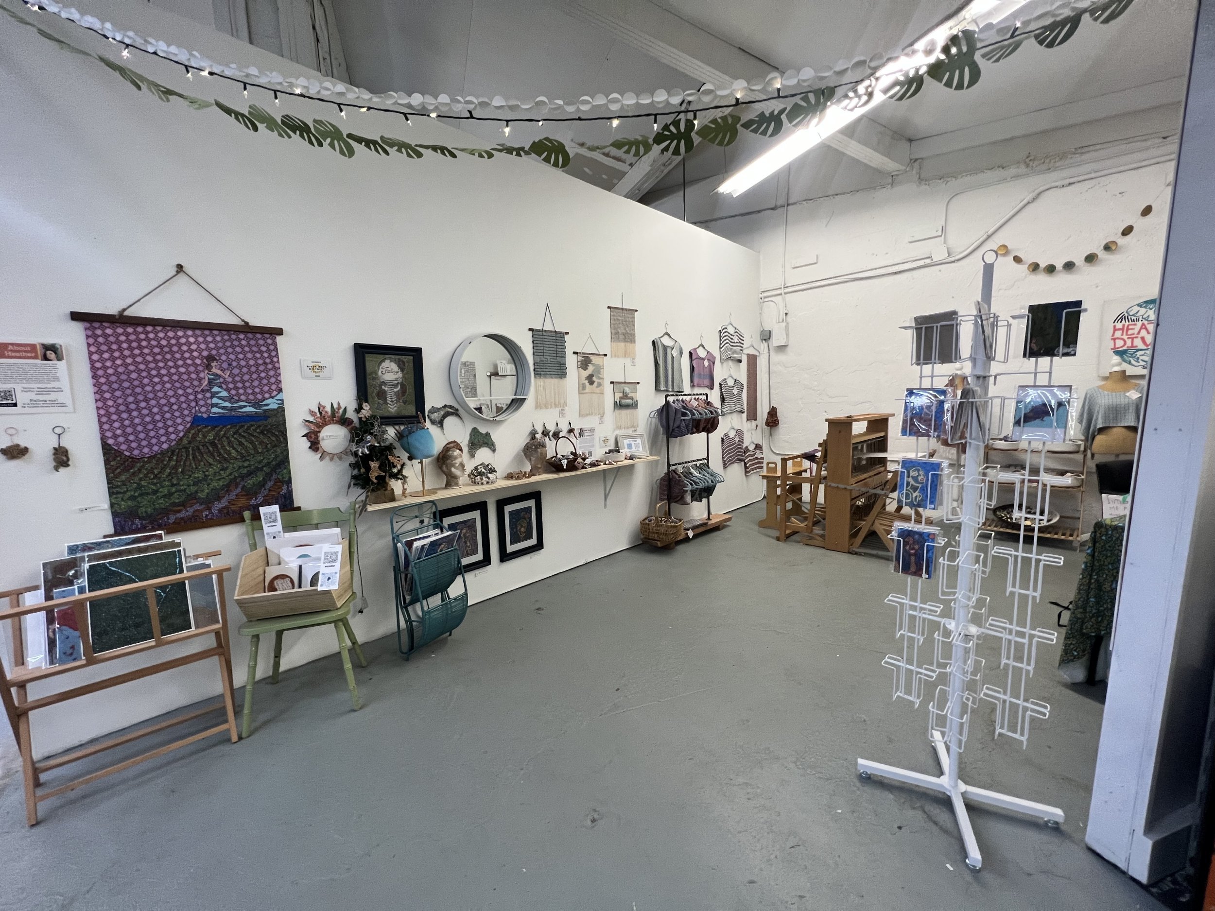 Heather's art studio at Pink Dog Creative. Her original artwork covers the walls, along with prints, cards, and artwork for sale.